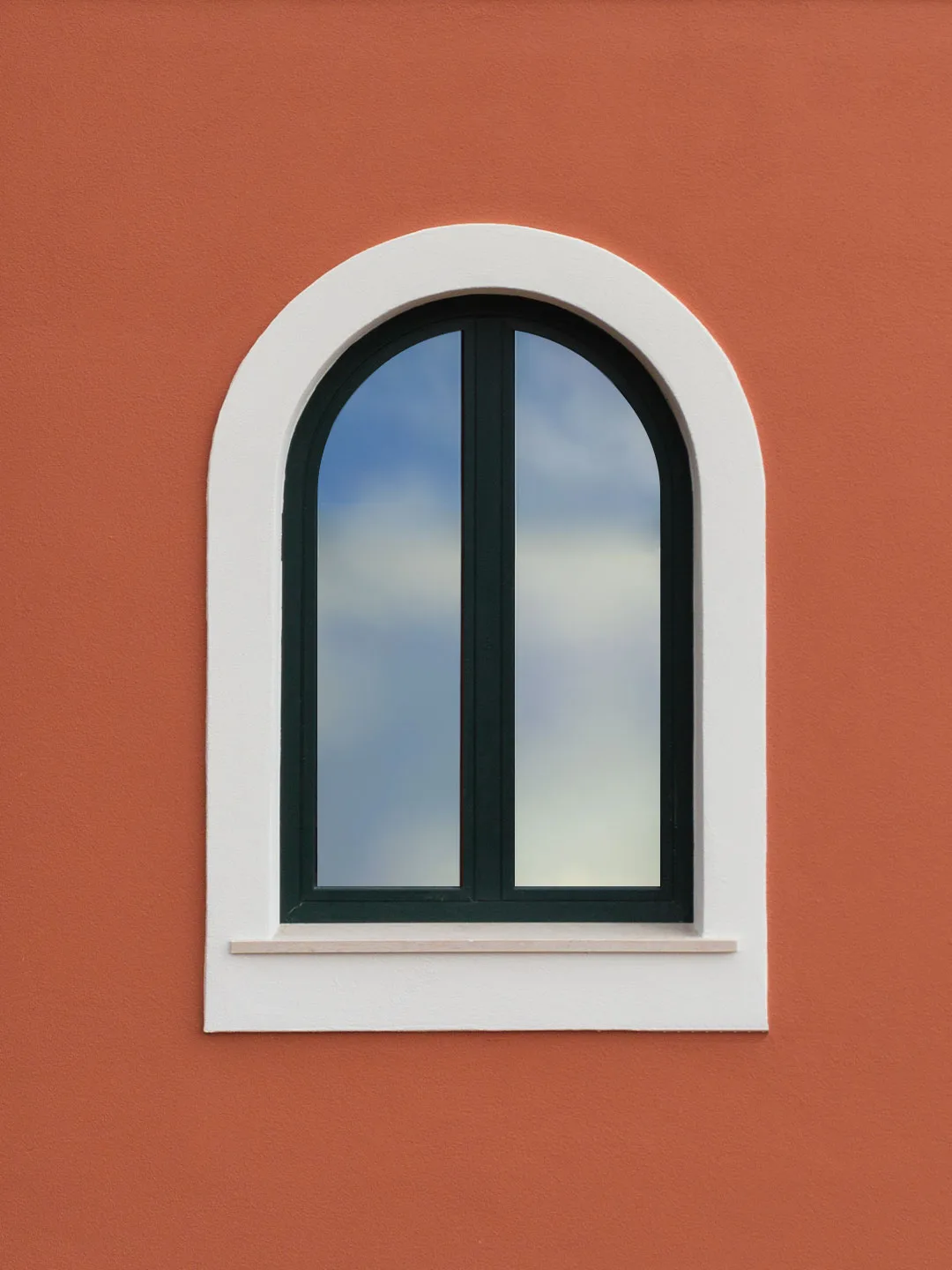 An arched window on the terracotta facade